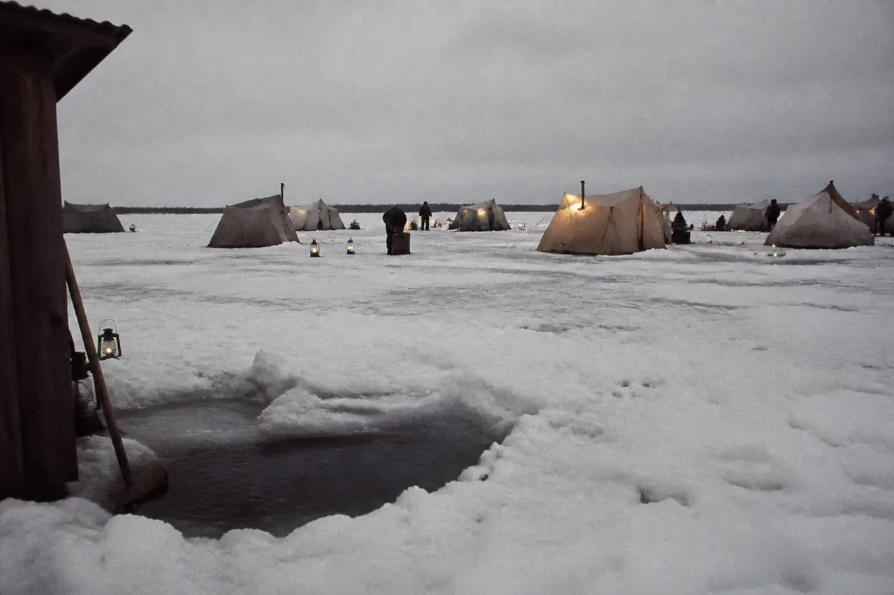 Quiet Ice Fish hole beside a crowded studio show hut